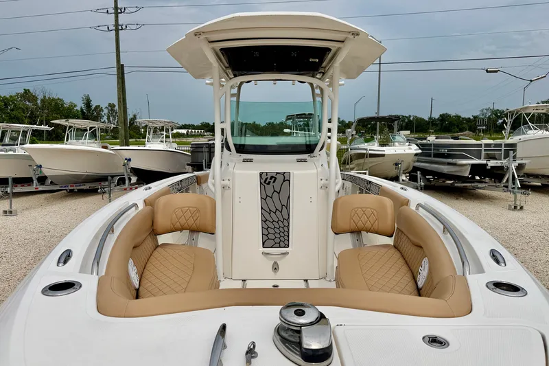 Slide: The Image of 2019 Wellcraft 262 Fisherman boat with tan seating, displayed in a marina setting. - 8