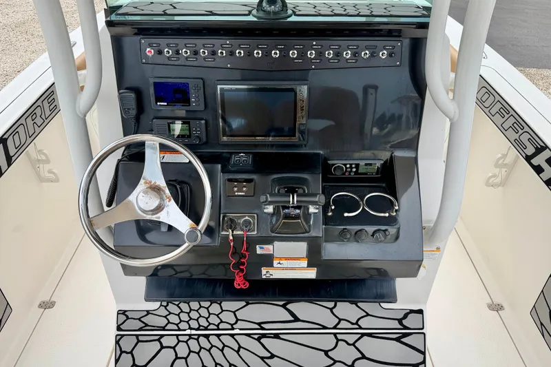 Slide: The Image of 2019 Wellcraft 262 Fisherman boat dashboard with steering wheel and electronic controls. - 13