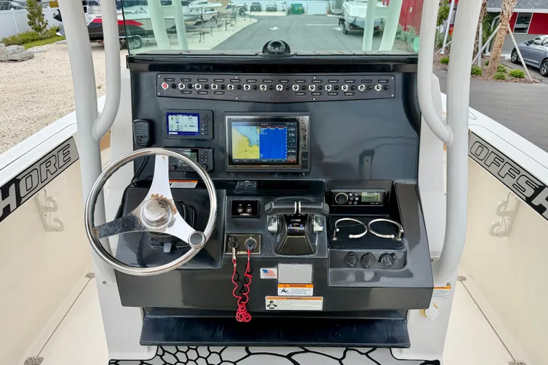 Slide: The Image of 2019 Wellcraft 262 Fisherman dashboard with steering wheel, navigation screens, and controls. - 14