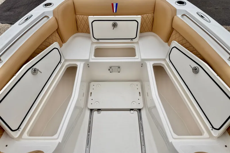 Slide: The Image of 2019 Wellcraft 262 Fisherman boat interior with open storage compartments and tan seating. - 30