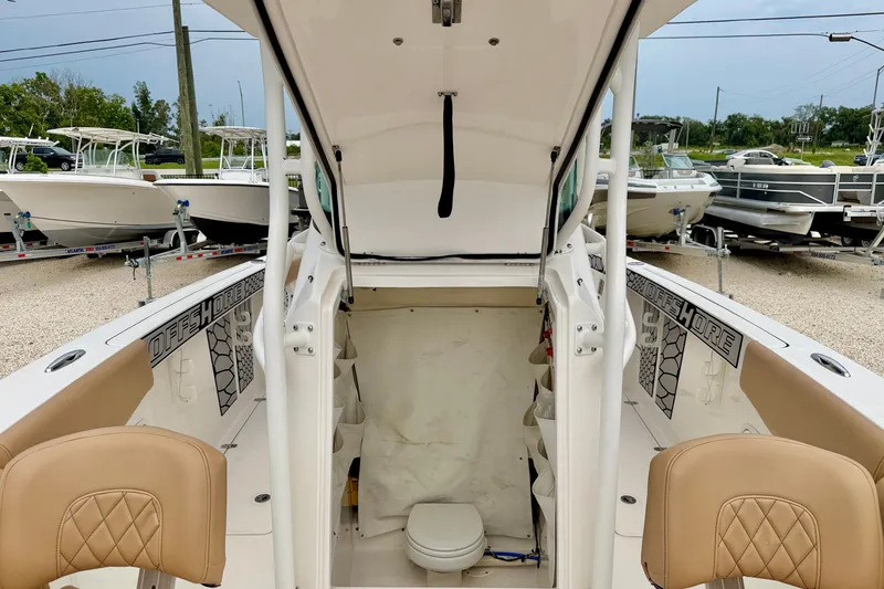 Slide: The Image of 2019 Wellcraft 262 Fisherman boat interior with seating and storage, displayed outdoors. - 21