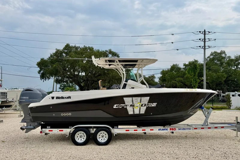 Slide: The Image of 2019 Wellcraft 262 Fisherman boat on trailer, parked outdoors under cloudy sky. - 4
