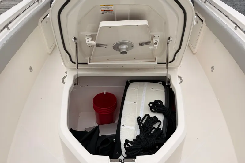 Slide: The Image of Storage compartment of 2026 Boston Whaler 330 Outrage boat with equipment and supplies. - 17