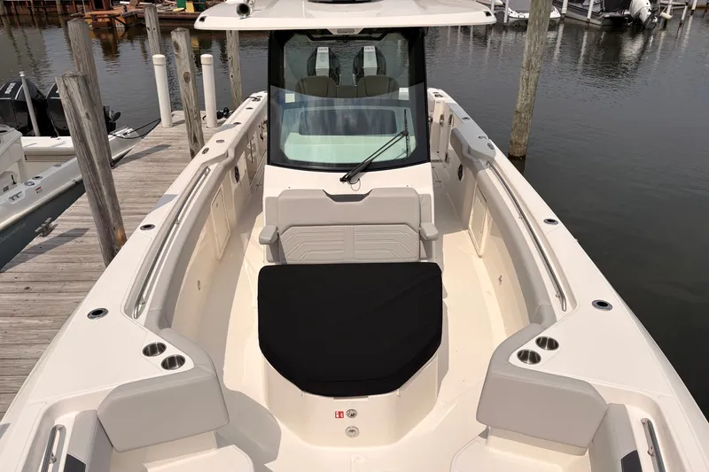 Slide: The Image of 2026 Boston Whaler 330 Outrage boat docked, showcasing spacious seating and sleek design. - 19