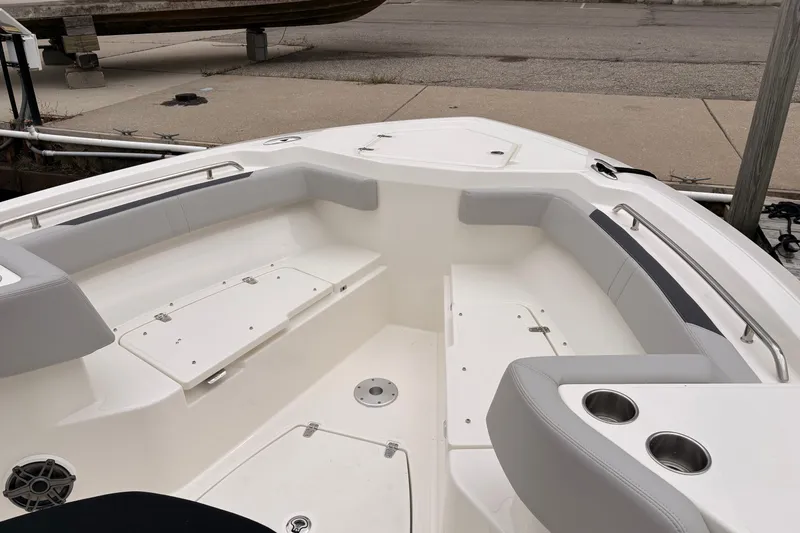 Slide: The Image of 2026 Boston Whaler 330 Outrage boat interior with cushioned seating and cup holders. - 15
