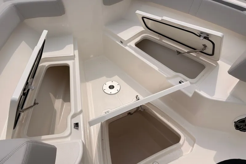 Slide: The Image of 2026 Boston Whaler 330 Outrage boat storage compartments open, showcasing spacious interior design. - 18