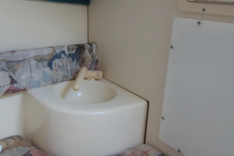 Slide: The Image of 1999 Sea Pro boat interior with compact sink and patterned upholstery. - 14