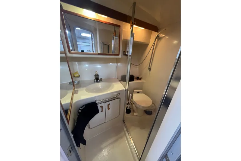 Slide: The Image of 1990 Sea Ray Sundancer 350 bathroom with sink, mirror, and shower. - 14