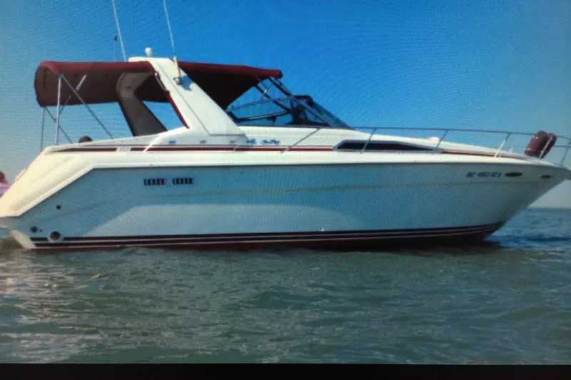 Slide: The Image of 1990 Sea Ray Sundancer 350 boat on water with blue sky background. - 2
