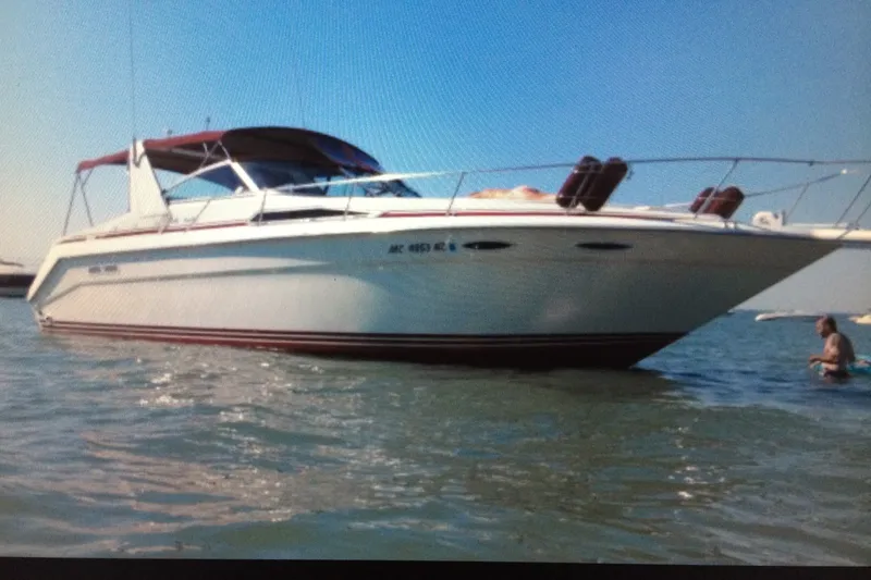 The Image of 1990 Sea Ray Sundancer 350 boat on calm water under clear blue sky. - 1
