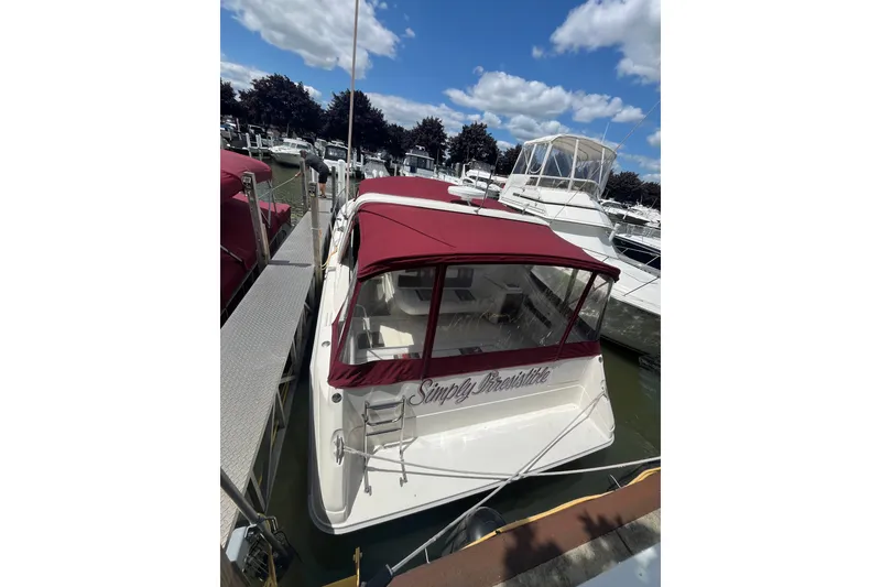 Slide: The Image of 1990 Sea Ray Sundancer 350 docked with maroon canopy under blue sky. - 17