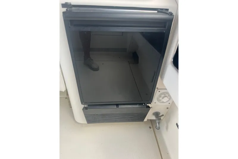 Slide: The Image of 1990 Sea Ray Sundancer 350 interior with a compact black refrigerator. - 8
