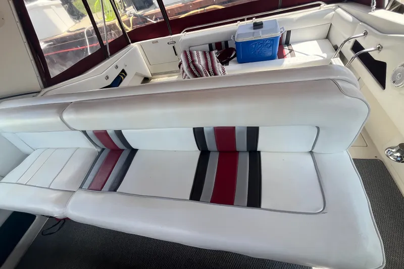Slide: The Image of Interior of 1990 Sea Ray Sundancer 350 with white and striped seating, cooler, and carpeted floor. - 6