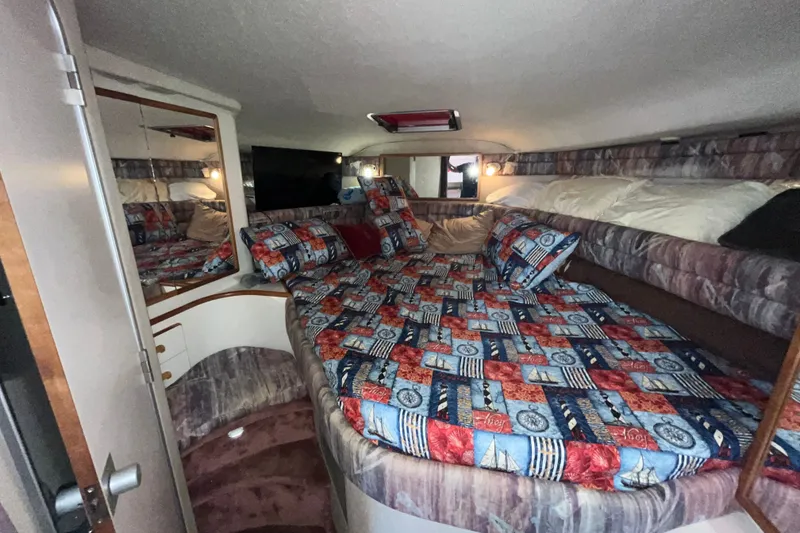 Slide: The Image of Cozy cabin interior of 1990 Sea Ray Sundancer 350 with colorful bedding and mirror. - 15