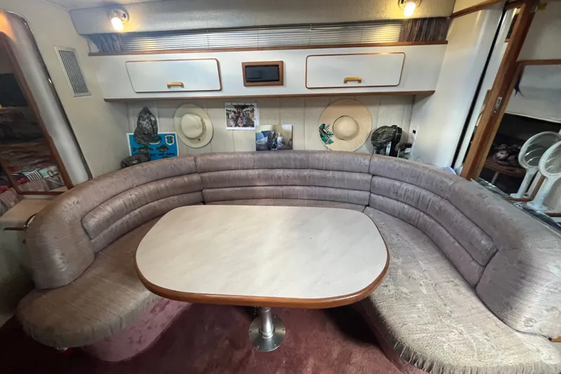 Slide: The Image of Interior of 1990 Sea Ray Sundancer 350 with curved seating and table. - 11