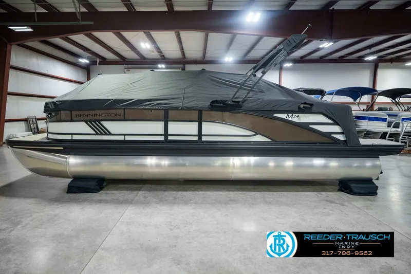 Slide: The Image of 2026 Bennington 24 MSB pontoon boat in showroom, covered and ready for display. - 58