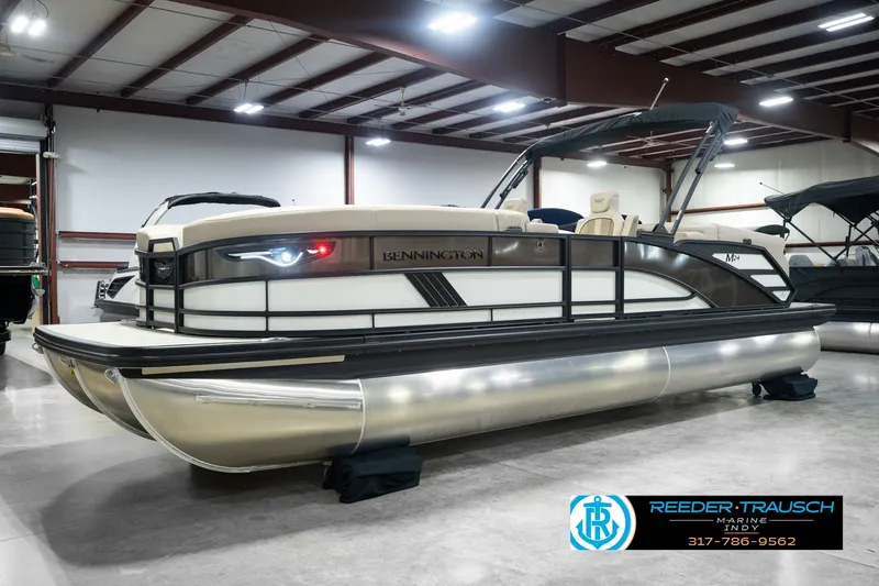 Slide: The Image of 2026 Bennington 24 MSB pontoon boat displayed indoors at Reeder-Trausch Marine showroom. - 1