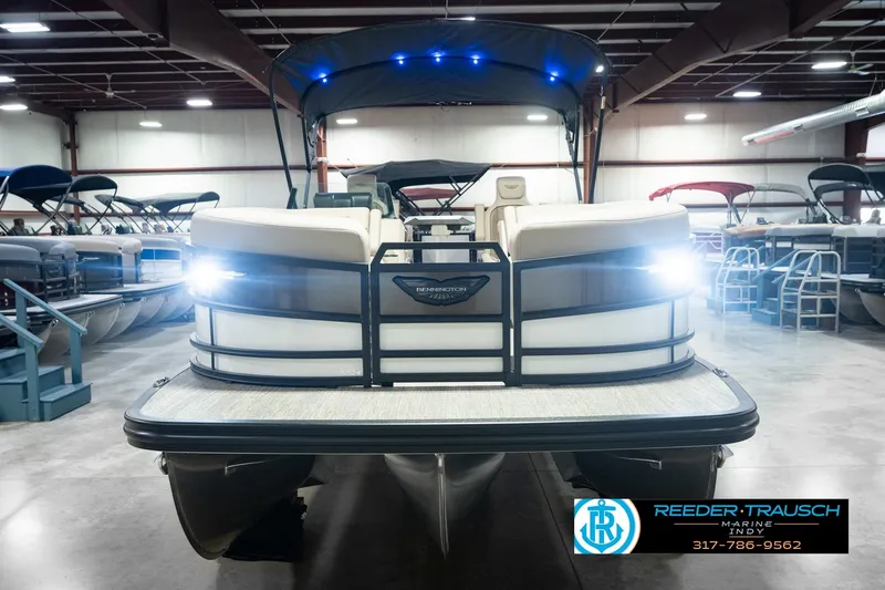 Slide: The Image of 2026 Bennington 24 MSB pontoon boat in showroom with bright headlights. - 4