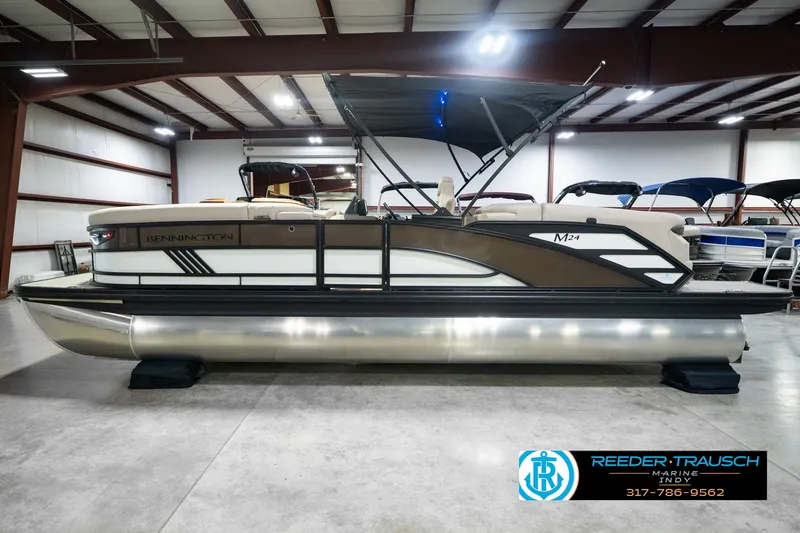 Slide: The Image of 2026 Bennington 24 MSB pontoon boat in showroom, featuring sleek design and modern amenities. - 12