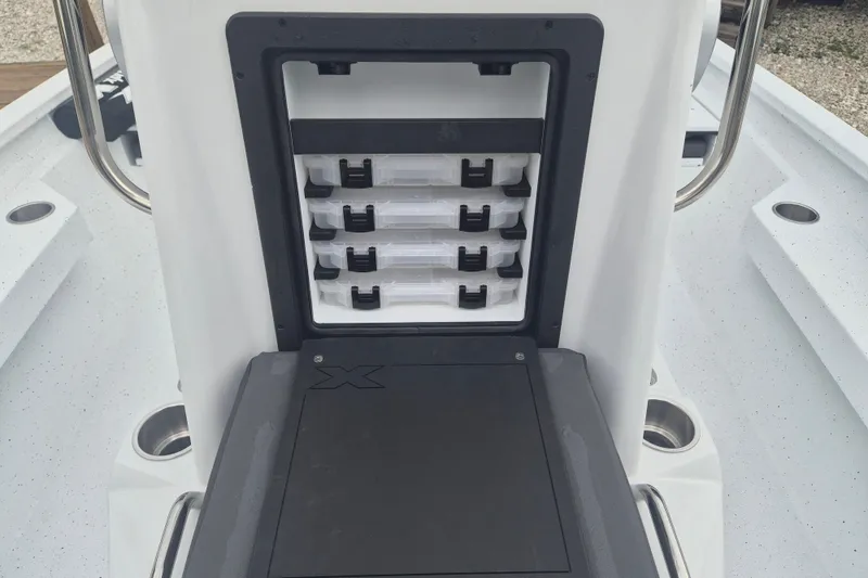 Slide: The Image of 2027 Xpress H20B Bay boat storage compartment with organized tackle boxes. - 17