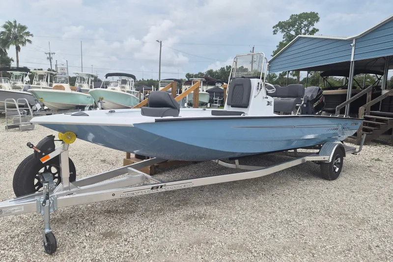 The Image of 2027 Xpress H20B Bay boat on trailer, displayed outdoors at a dealership. - 0