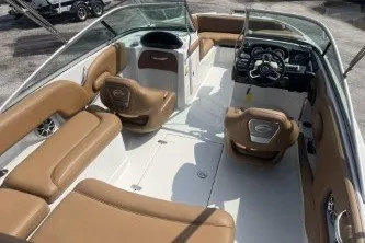 Slide: The Image of 2023 Crownline Eclipse E215 XS boat interior with tan seating and modern dashboard. - 8
