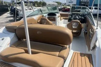 Slide: The Image of 2023 Crownline Eclipse E215 XS boat interior with tan seating and modern dashboard. - 7