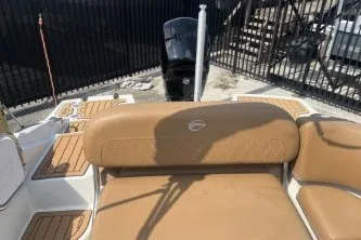 Slide: The Image of 2023 Crownline Eclipse E215 XS boat interior with tan seating and wood accents. - 12