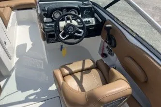 Slide: The Image of 2023 Crownline Eclipse E215 XS boat interior with tan seating and modern dashboard. - 9