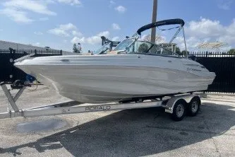 Slide: The Image of 2023 Crownline Eclipse E215 XS boat on trailer, parked outdoors under blue sky. - 4