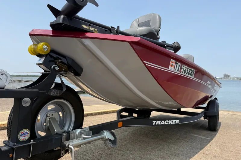 Slide: The Image of 2020 Tracker Pro 160 boat on trailer near water, featuring Minn Kota motor. - 18