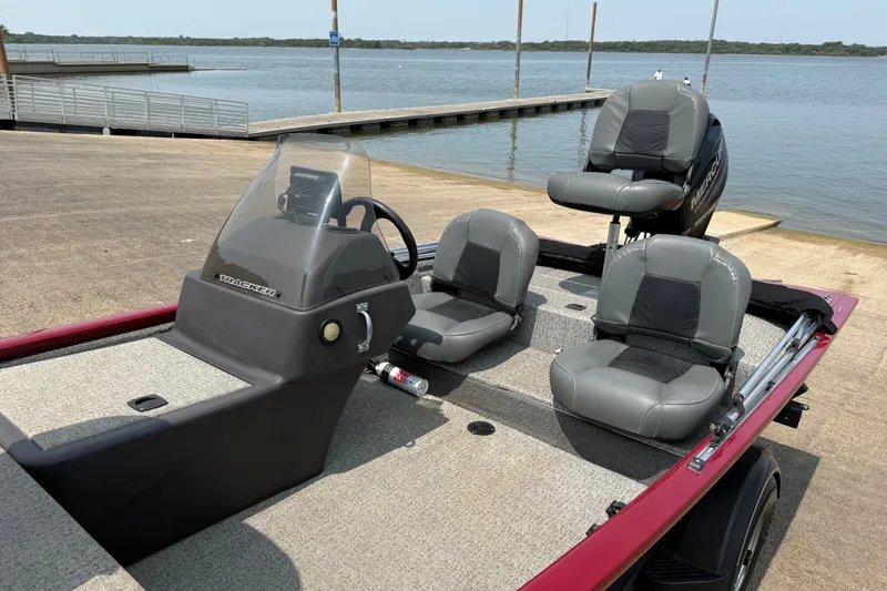 Slide: The Image of 2020 Tracker Pro 160 boat with gray seating, docked by a serene lake. - 23