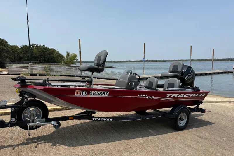 Slide: The Image of 2020 Tracker Pro 160 boat on trailer by a lake, ready for fishing. - 16