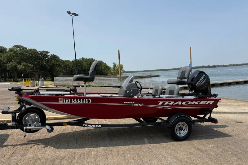 Slide: The Image of 2020 Tracker Pro 160 boat on trailer by a lake, ready for fishing. - 15