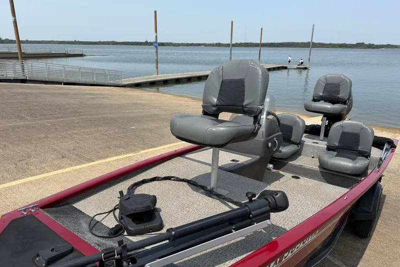Slide: The Image of 2020 Tracker Pro 160 boat docked by a serene lake with seating. - 19