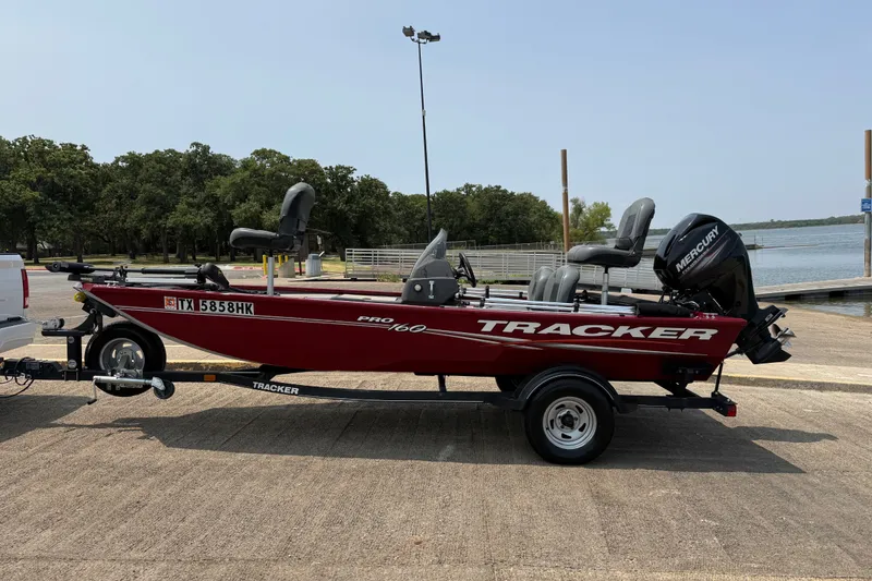 Slide: The Image of 2020 Tracker Pro 160 boat on trailer by lakeside, featuring Mercury engine. - 14