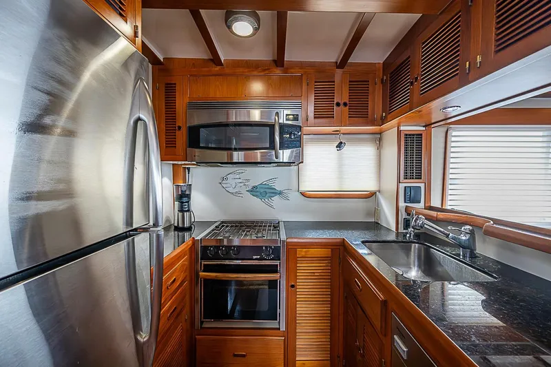 Slide: The Image of Luxurious 2008 Krogen 48 North Sea yacht kitchen with stainless steel appliances and wooden cabinetry. - 22
