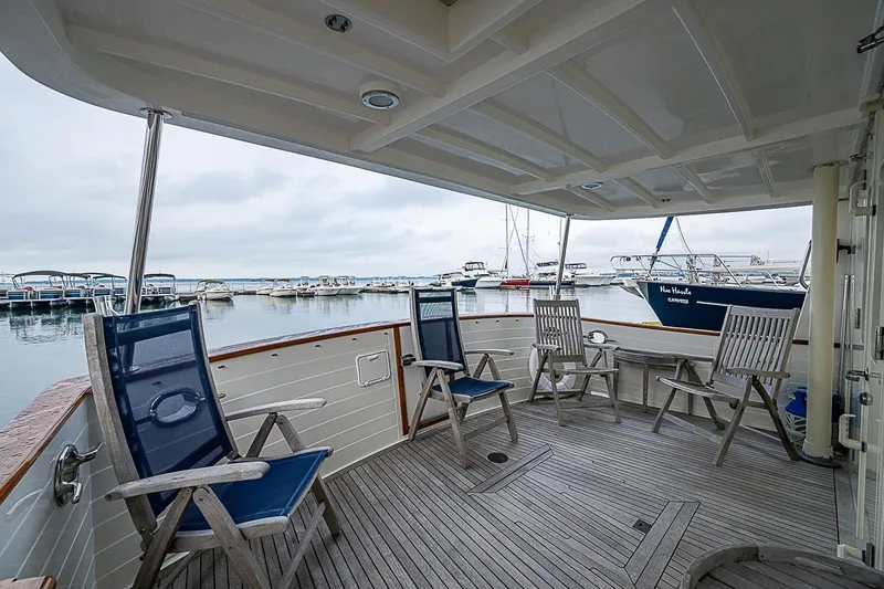 Slide: The Image of Covered deck of 2008 Krogen 48 North Sea yacht with chairs, overlooking marina. - 47