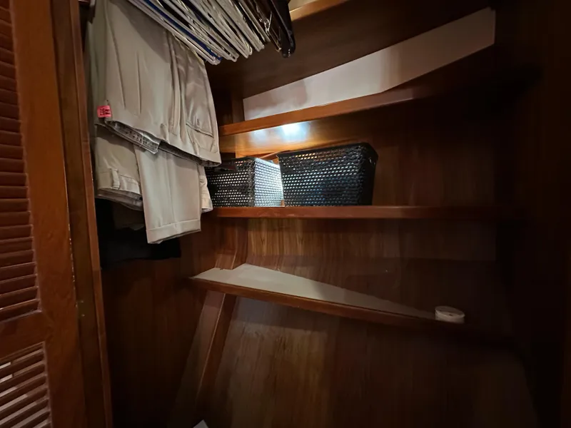 Slide: The Image of Wooden closet interior with shelves, hanging clothes, and storage baskets on a Kadey-Krogen 48 Whaleback. - 24
