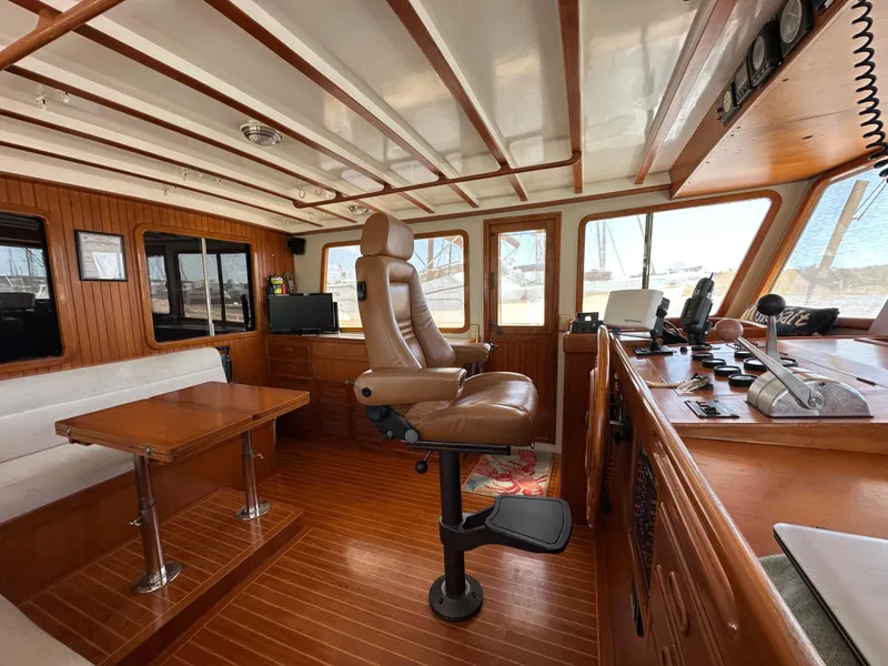 Slide: The Image of 1997 Kadey-Krogen 48 Whaleback interior with captain's chair, wooden table, and navigation equipment. - 41