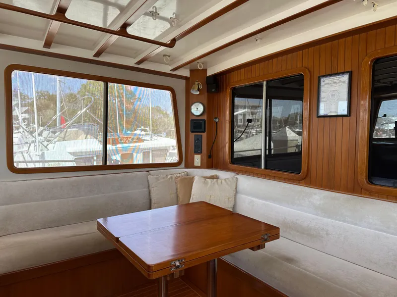 Slide: The Image of Interior of 1997 Kadey-Krogen 48 Whaleback yacht with wooden table and cushioned seating. - 45