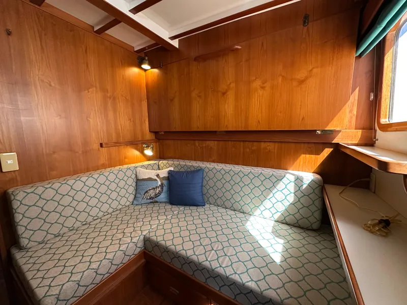 Slide: The Image of Cozy seating area in 1997 Kadey-Krogen 48 Whaleback yacht with wooden interior and cushions. - 29
