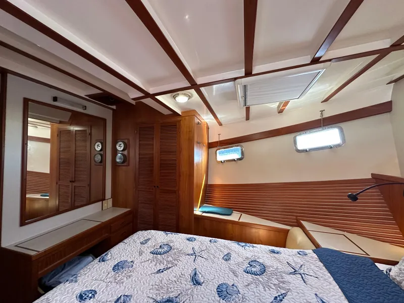 Slide: The Image of 1997 Kadey-Krogen 48 Whaleback cabin with wooden interior and nautical-themed bedding. - 22
