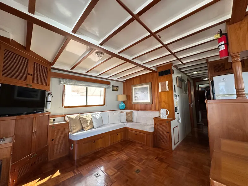 Slide: The Image of Interior of 1997 Kadey-Krogen 48 Whaleback yacht, featuring cozy seating and wooden finishes. - 10