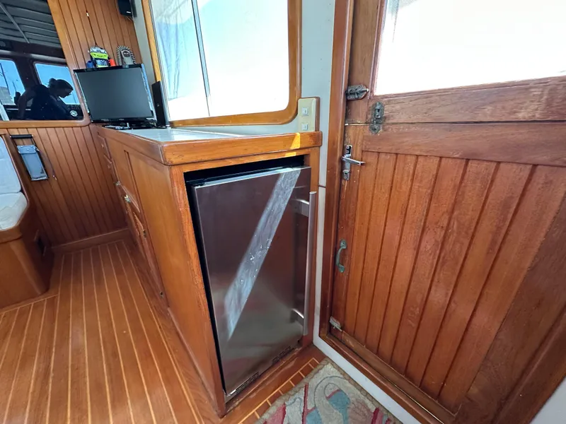 Slide: The Image of 1997 Kadey-Krogen 48 Whaleback interior with wood paneling and compact fridge. - 46