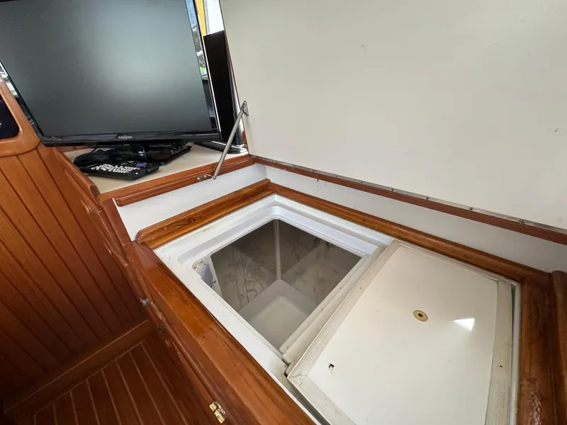 Slide: The Image of 1997 Kadey-Krogen 48 Whaleback interior with open storage compartment and monitor. - 47