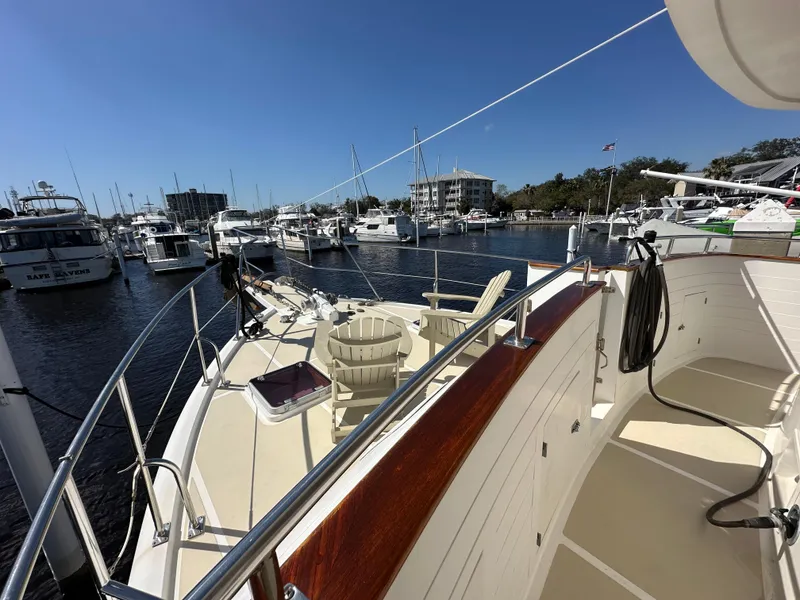 Slide: The Image of 1997 Kadey-Krogen 48 Whaleback yacht docked at marina under clear blue sky. - 50