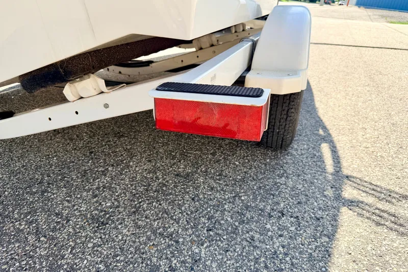 Slide: The Image of Trailer of 2008 Sea Ray 195 Sport boat on pavement, featuring red reflector. - 75
