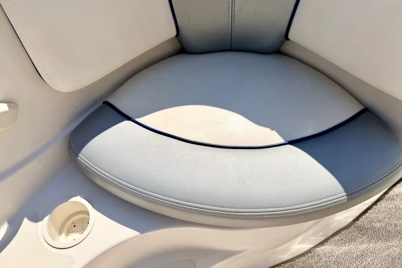 Slide: The Image of 2008 Sea Ray 195 Sport boat seat with cup holder, featuring light gray upholstery. - 60