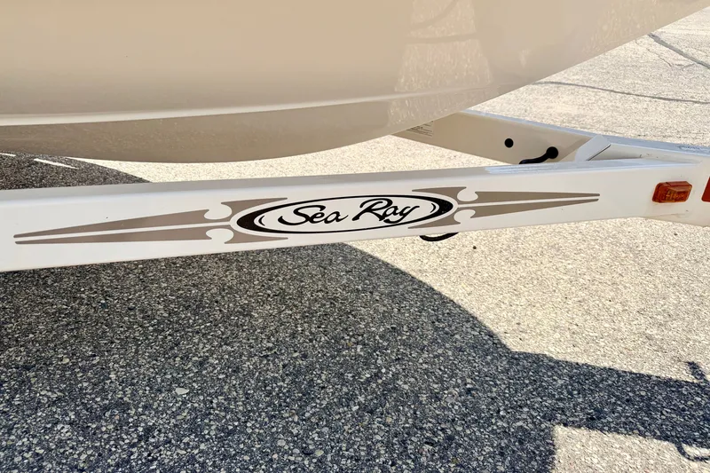 Slide: The Image of 2008 Sea Ray 195 Sport boat trailer with logo on pavement background. - 77